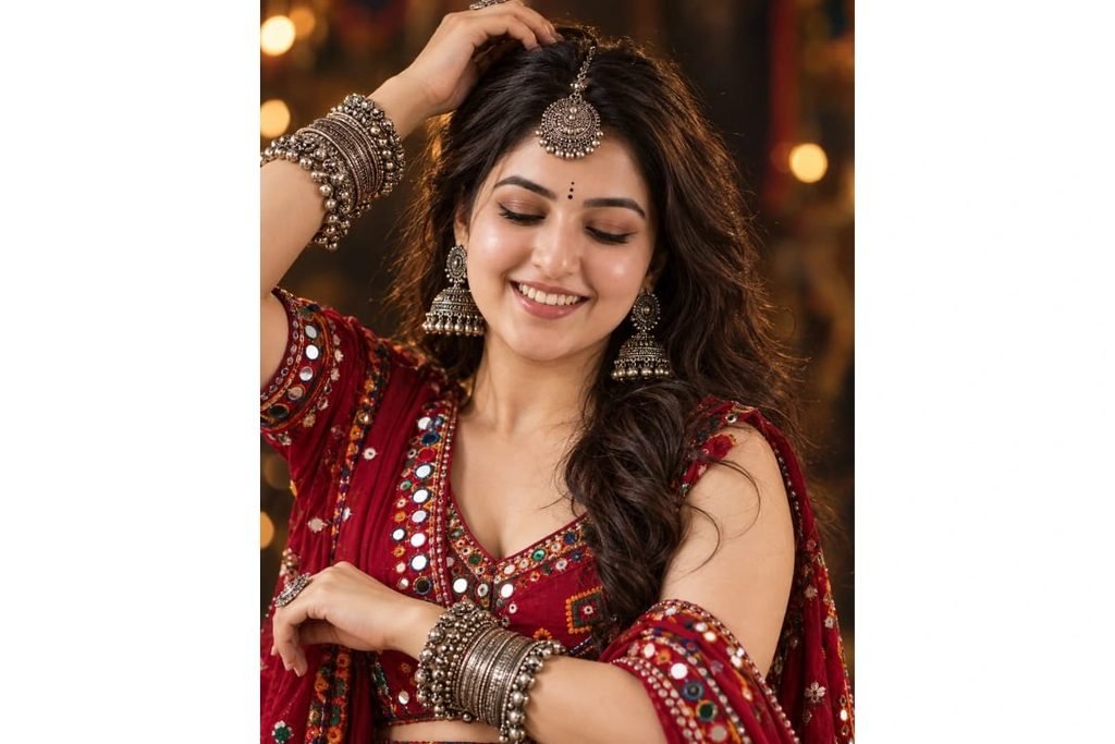 Gujarati Garba girl wearing a red mirror-work chaniya choli with traditional silver jhumka earrings, maang tikka and stacked bangles for Navratri