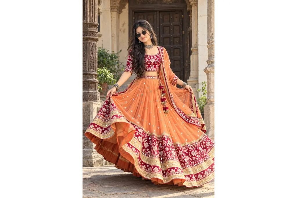 SEO-Friendly Alt Text: Orange and peach Gujarati Navratri lehenga choli with pink floral embroidery and a traditional flared skirt, festive Garba outfit inspiration for girls