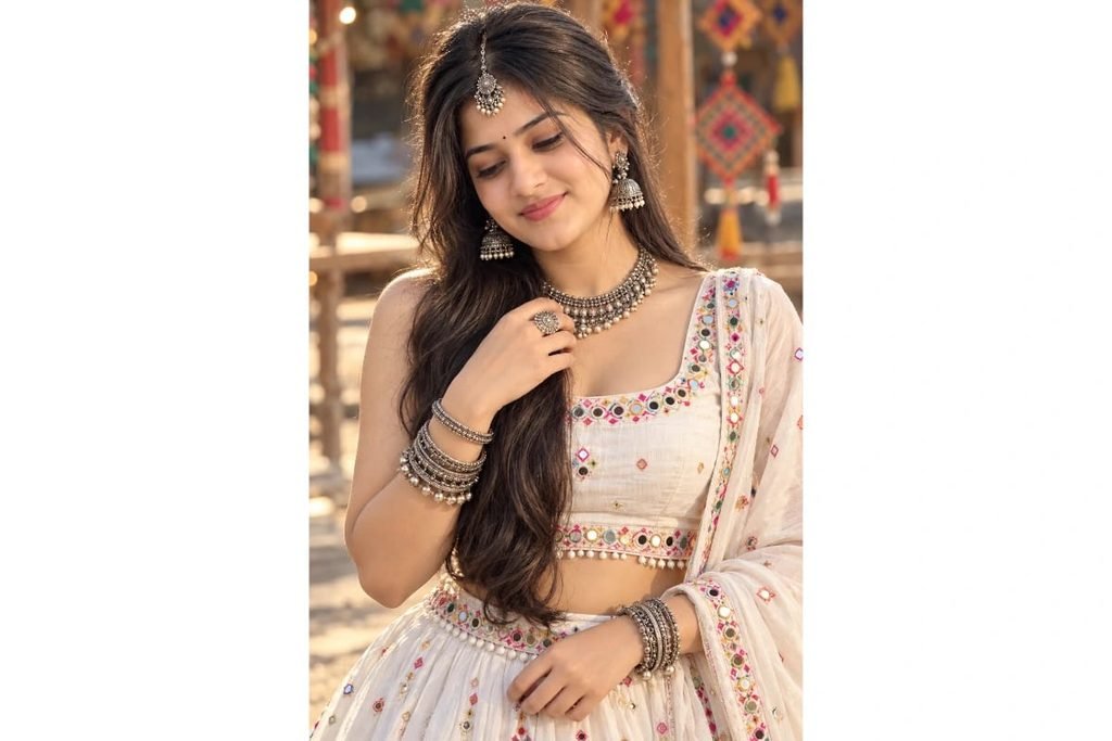 Modern white Gujarati Garba outfit with pastel embroidery, traditional silver jewelry, jhumka earrings and maang tikka for Navratri