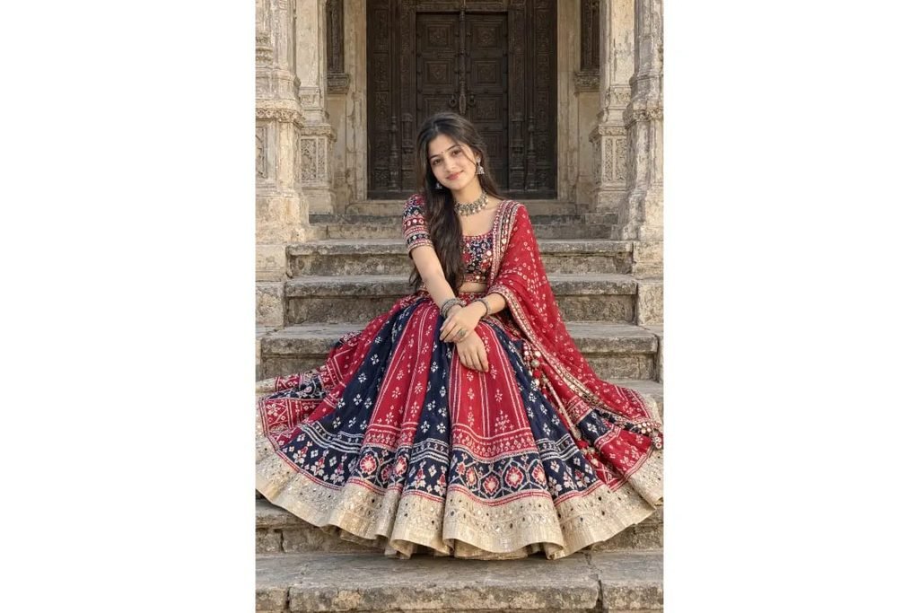 SEO-Friendly Alt Text: Red and navy blue Gujarati Navratri lehenga choli with traditional folk embroidery and beige borders, ethnic Garba outfit photoshoot at a heritage haveli